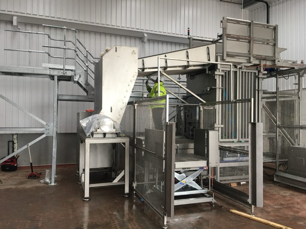 Stainless steel pallet tipper installation in food processing facility